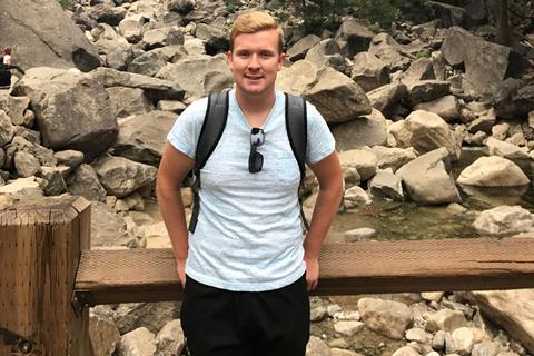 Jamie smiling with rocks and a stream in the background.