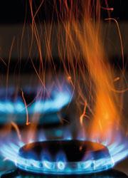 A gas hob showing a blue and orange flame