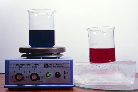 An experiment showing a beaker of deep purple liquid on a heater and a beaker of pink liquid on ice