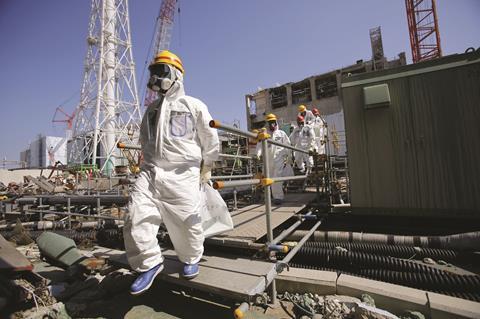 People in white overalls, gas masks and helmets