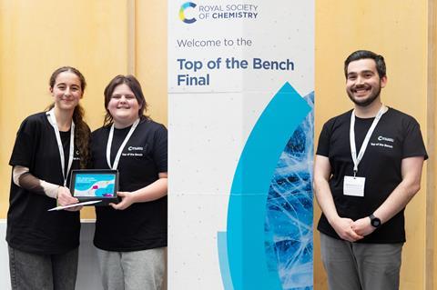 Students collecting a trophy and certificates from a presenter for the RSC Top of the Bench competition