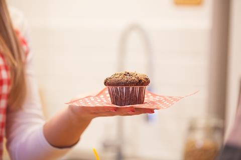 Cupcake on a red and white napkin on an outstretched hand