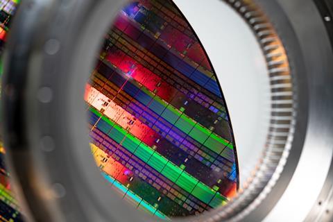 A ring of a magnifying lens showing a silicon microchip reflecting rainbow colours