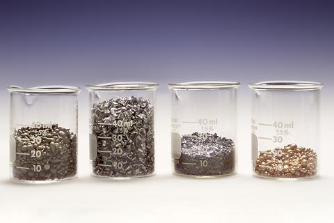 Four glass beakers holding different volumes of different metals