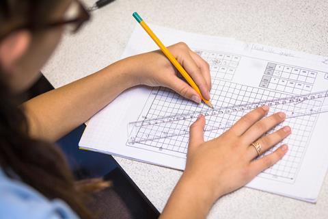 A photo of a school student drawing a graph