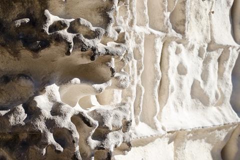 A photograph showing acid range damage and chemical weathering to the limestone walls of a church in Italy