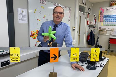 Graham Hewston holding a balloon model of electron orbitals in his science classroom