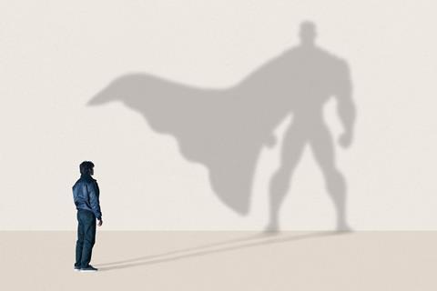 An ordinary young man with a superhero shaped shadow