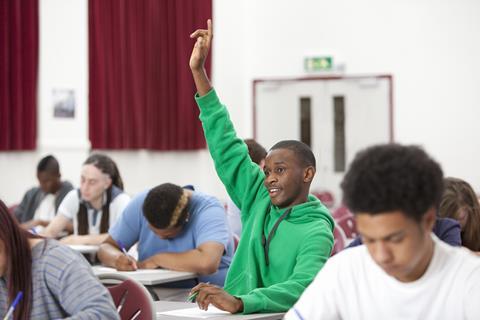 A photograph showing a black student answering a question in class