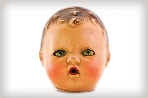 A photo of an old plastic doll's head