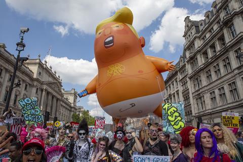 A photo of a protest in London with a large inflatable shaped like a baby Donald Trump 
