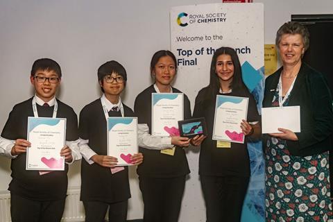 Four students holding certificates with Gill Reid