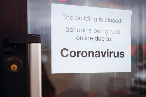 An image showing a close-up of a door with a sign saying: The building is closed. School is being held online due to coronavirus