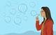 A woman blowing bubbles in the shape of speech bubbles