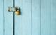 Metal padlock on blue door