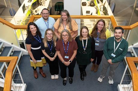 A group photograph featuring education coordinators for the Royal Society of Chemistry standing together on a staircase, smiling upwards towards the camera